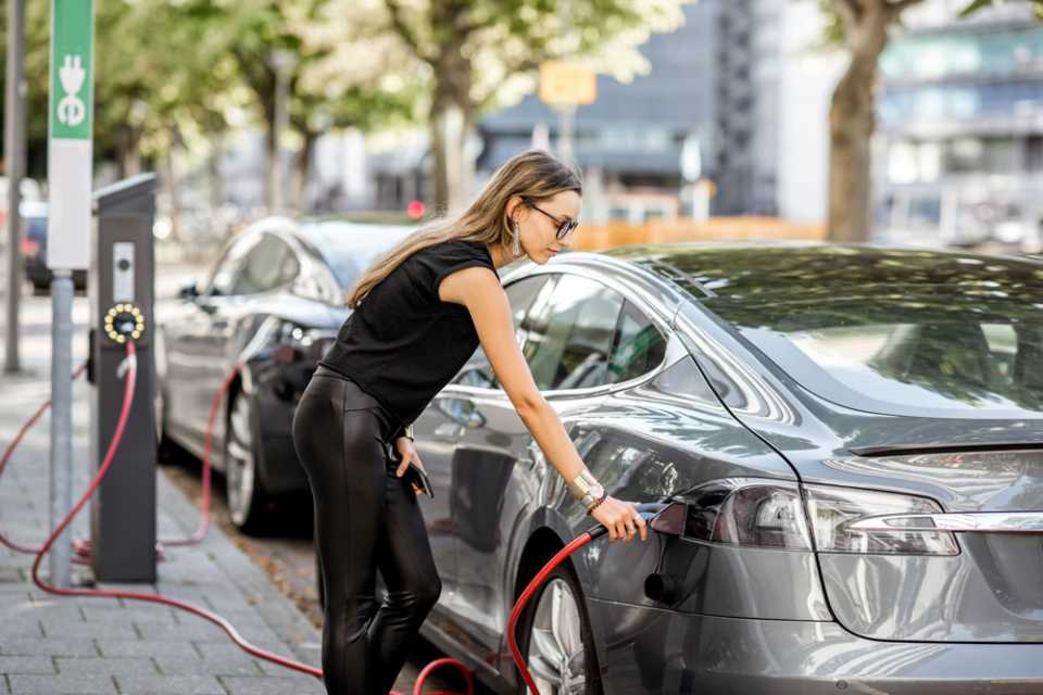 Woman charging her car at the side of the road