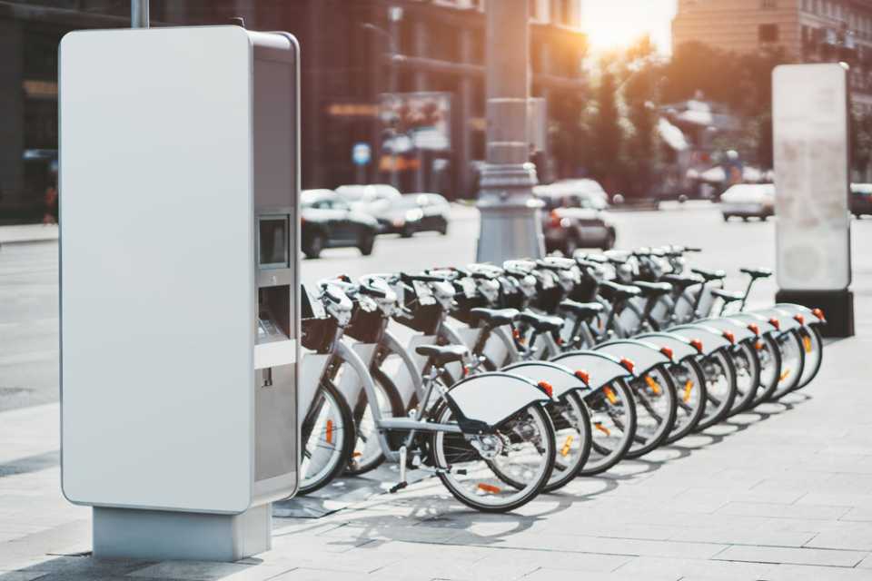 A row of electric bikes on a public pavement.