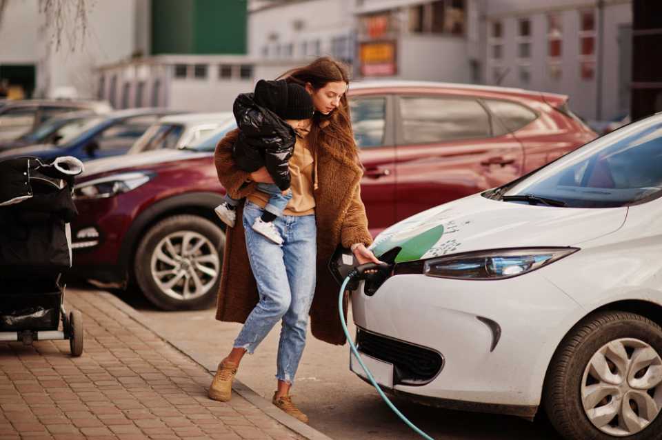 Woman charging car in car park