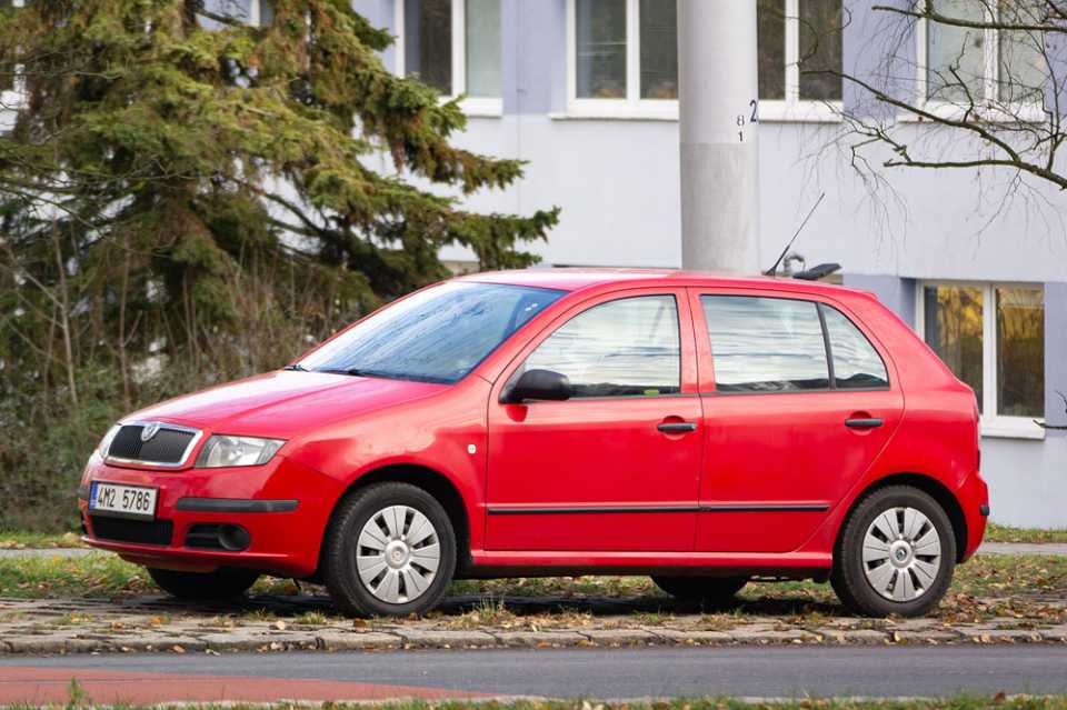 Red Skoda parked on kerb